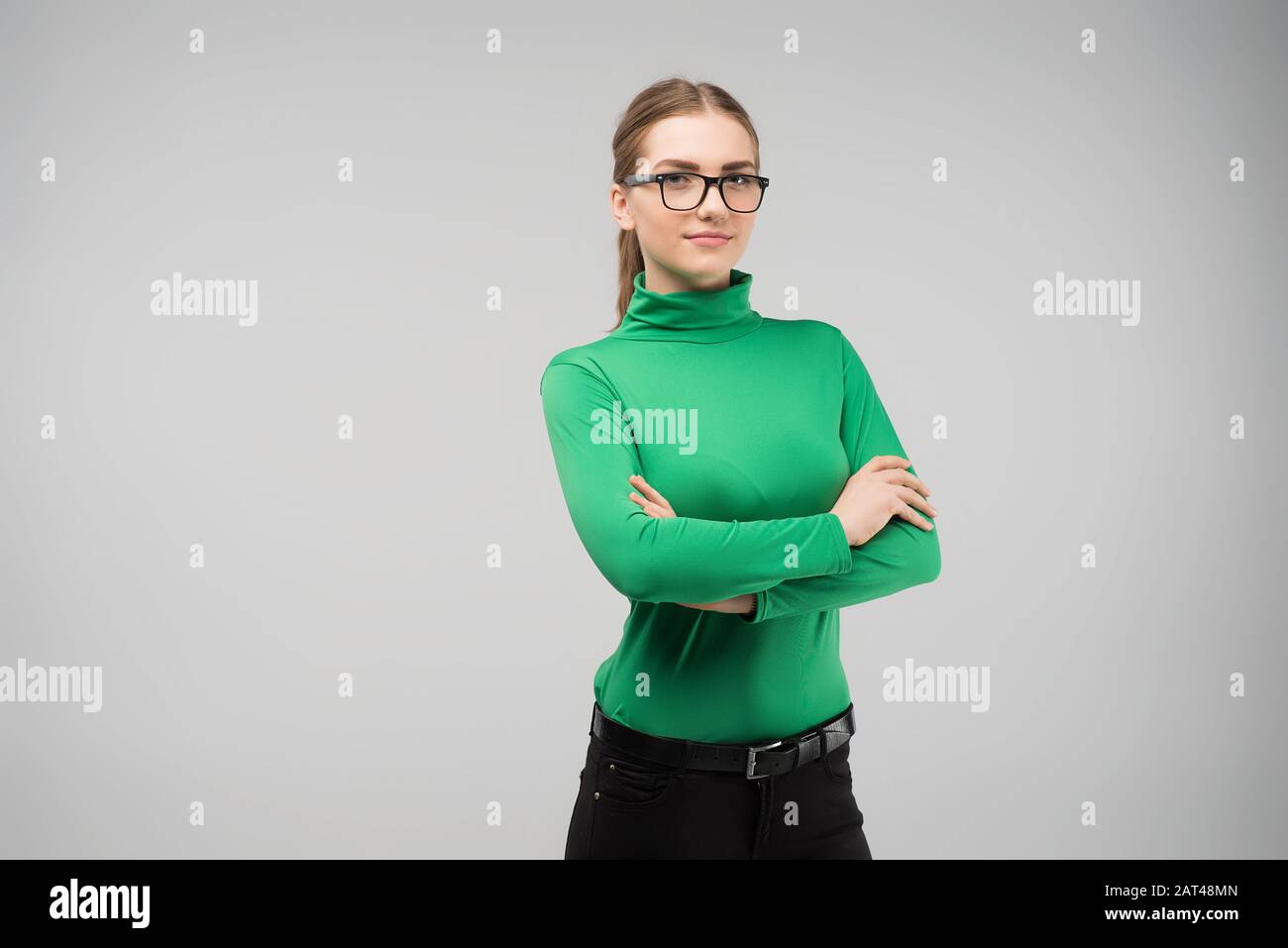 Giovane ragazza in abiti modesti si leva le braccia incrociate Foto Stock