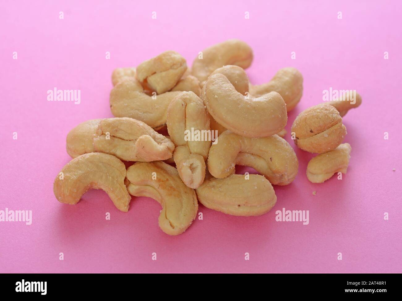 Un gruppo cashew su tavolo rosa Foto Stock