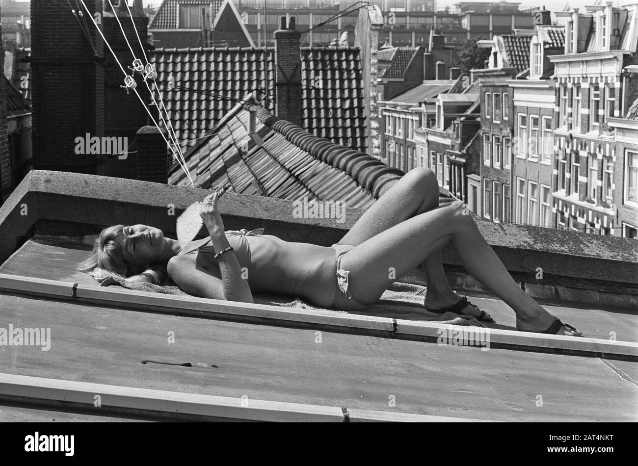 La più calda giornata estiva ad Amsterdam la giovane donna prende il sole in una grondaia Data: 4 agosto 1975 luogo: Amsterdam, Noord-Holland Parole Chiave: Immagini della città, attività ricreative, donne, calore, estate Foto Stock