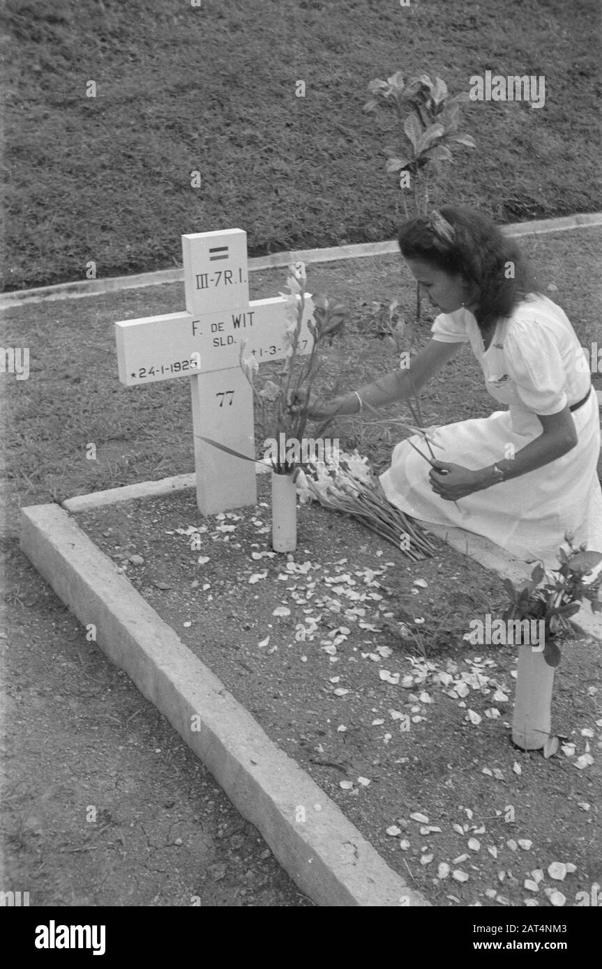 Fiori per la celebrazione dei morti e di Natale a Semarang giovane donna posa fiori sulla tomba di F. de Wit, soldato III-7 R.I. nato 24-1-1925 morto 1-3-1947 Data: 25 dicembre 1947 luogo: Indonesia, Indie orientali olandesi Foto Stock