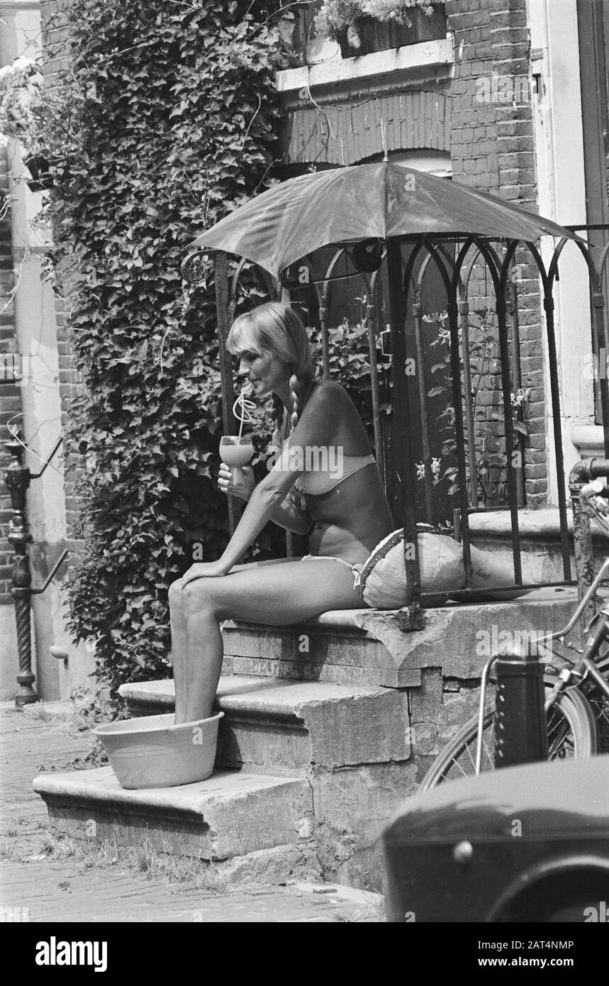 Giovane donna in bikini seduta sul marciapiede in bagno di piede bere limonata Data: 31 luglio 1978 Parole Chiave: Bikini, Signore Foto Stock