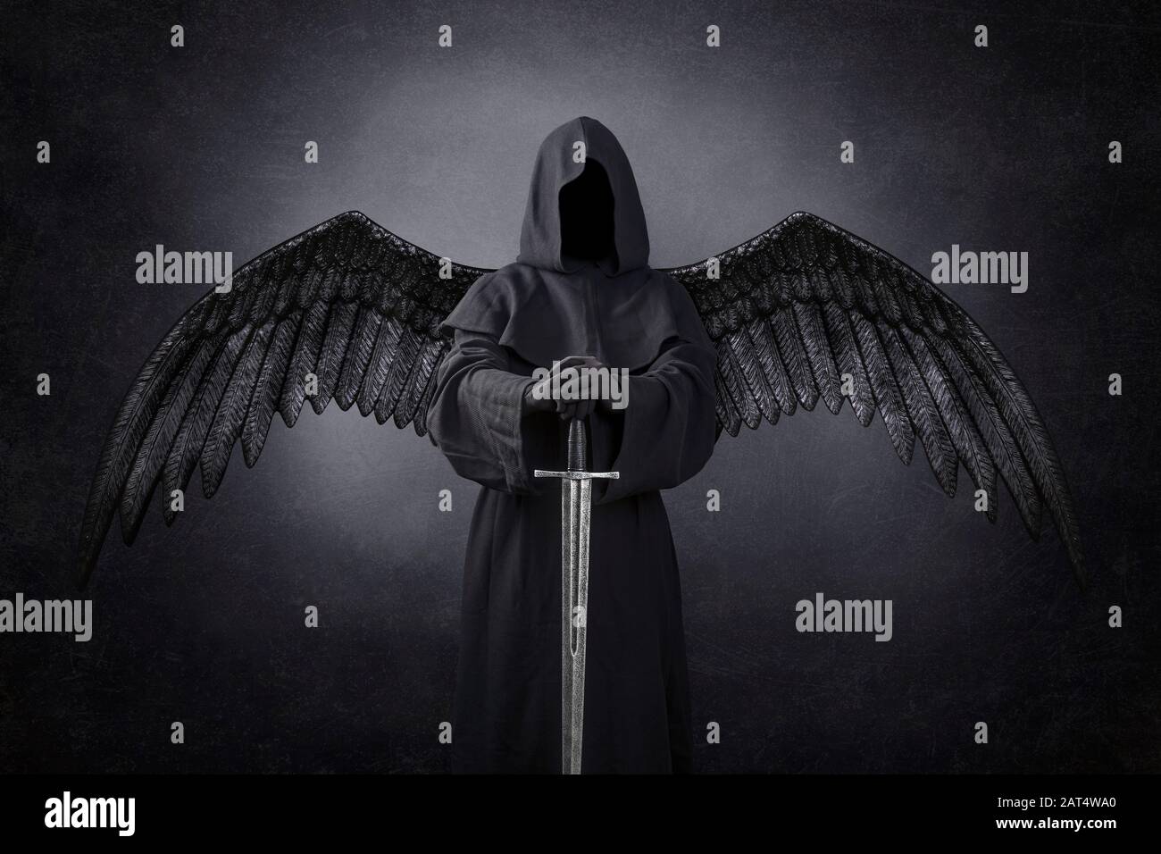 Angelo scuro con spada medievale al buio Foto Stock