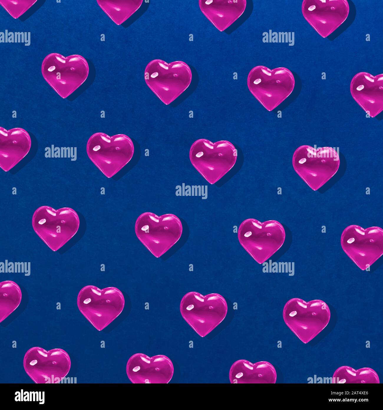 San Valentino sfondo. Motivo di cuori rosa di vetro su sfondo blu. Carta Minimalismo, Simbolo Di Amore Foto Stock