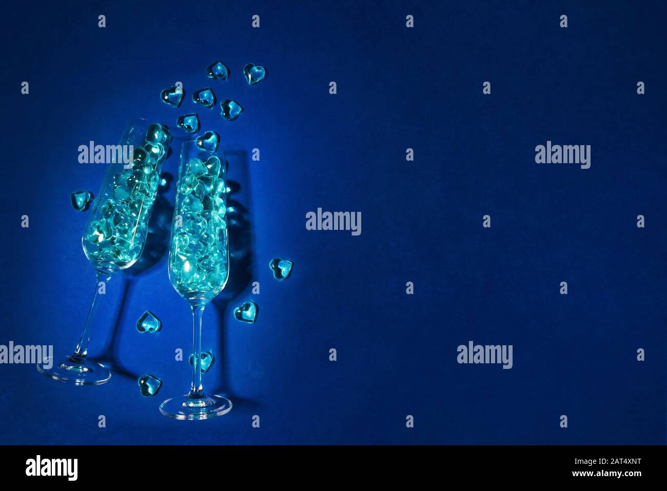 Festive sfondo classico blu per una festa, celebrazione. Bicchieri di champagne pieni di cuori blu. Concetto di festa LGBT Foto Stock