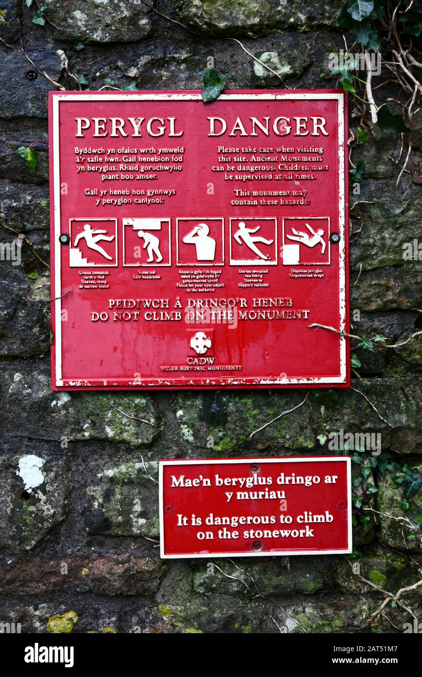 Registrati in gallese e inglese avvertimento persone di non salire su muri di pietra, Coity Castle, Mid Glamorgan, Galles, Regno Unito Foto Stock