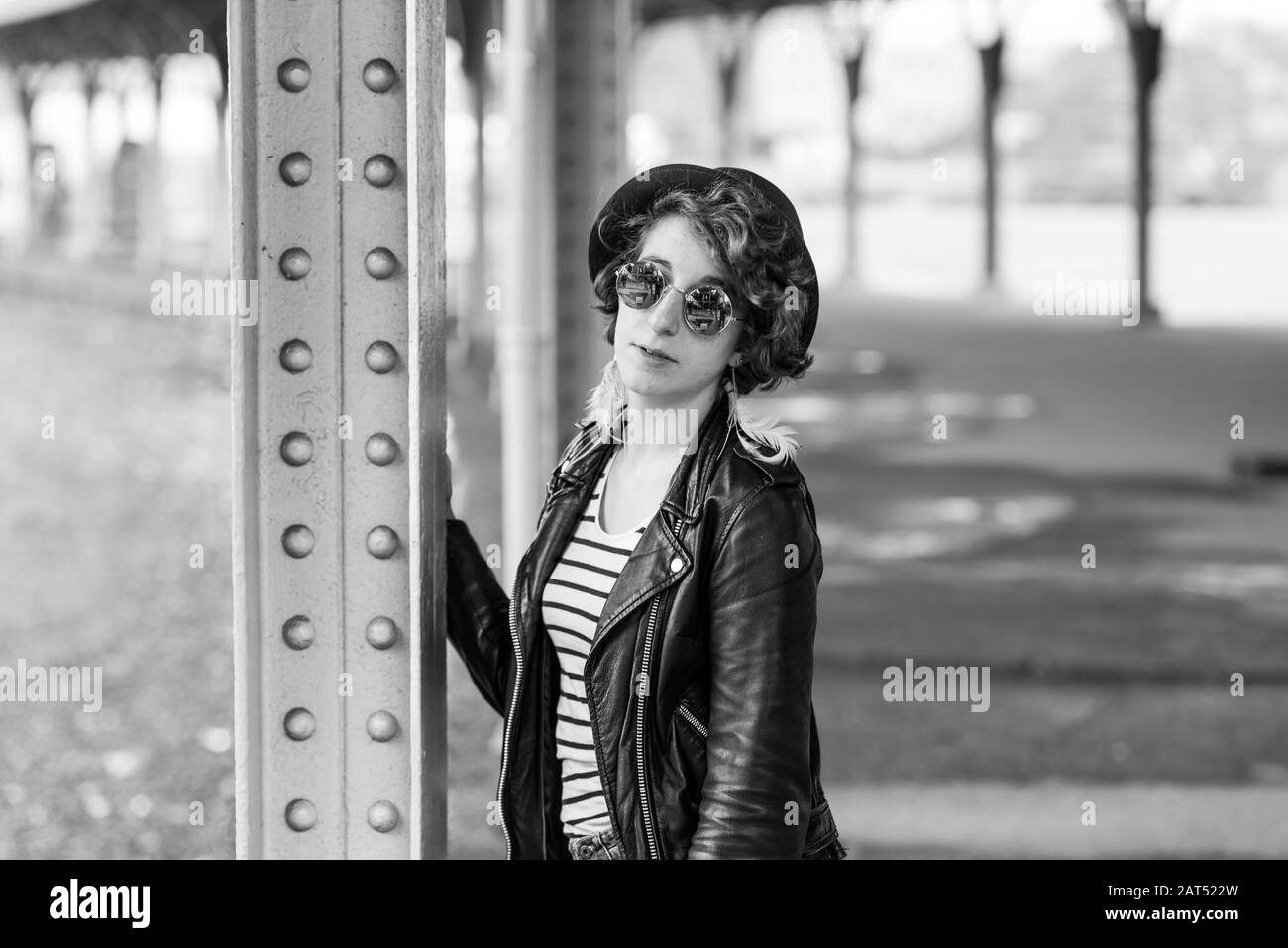 Ritratto di una donna di venti anni che indossa una giacca in pelle nera e occhiali da sole Foto Stock