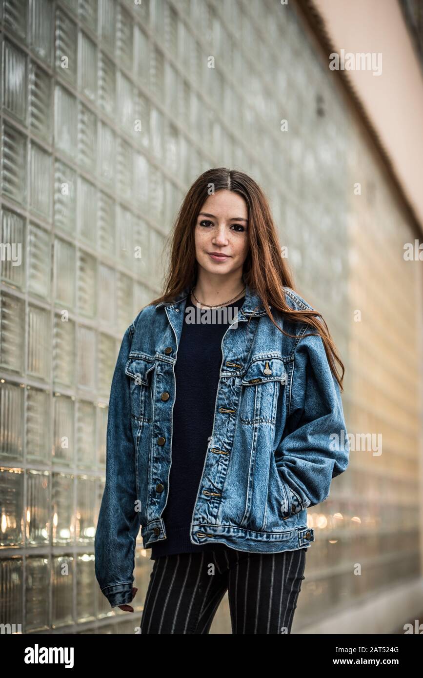 Attraente 18 anni ragazza del college con capelli rossi in giacca jeans che  posano contro una parete di vetro Foto stock - Alamy