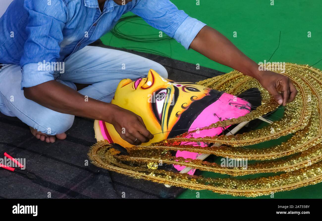 Artista locale che lavora su una maschera facciale tradizionale usata per una danza popolare indiana regionale a una tariffa artigianale a Kolkata Foto Stock
