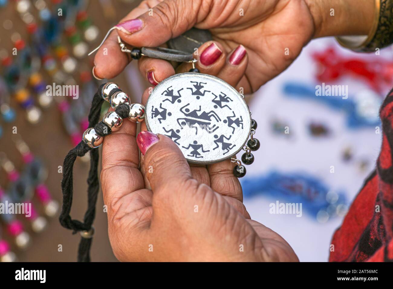 Mani di un cliente donna che tiene una collana femminile fatta a mano prima di acquistare Foto Stock