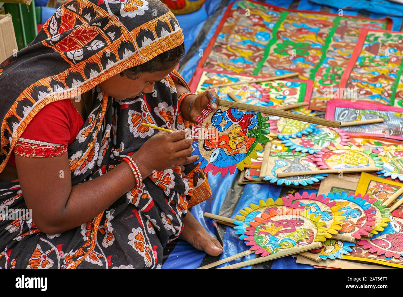 Donna indiana artista lavoratore fare pittura di tessuto con pennello su un oggetto artigianale a una tariffa artigianale a Calcutta, India Foto Stock