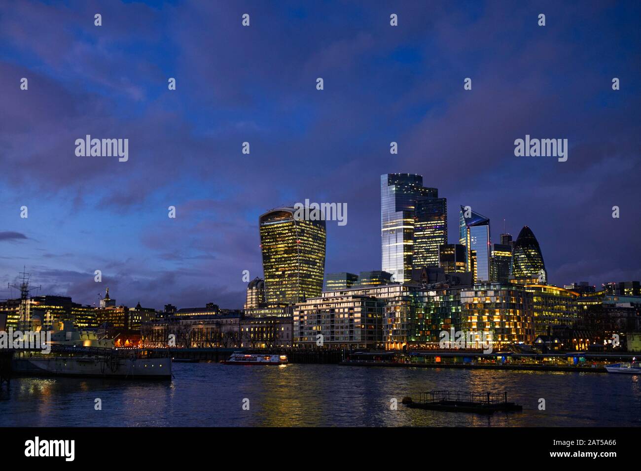 Skyline della città di Londra di notte con alti uffici illuminati contro il cielo di prima sera Foto Stock