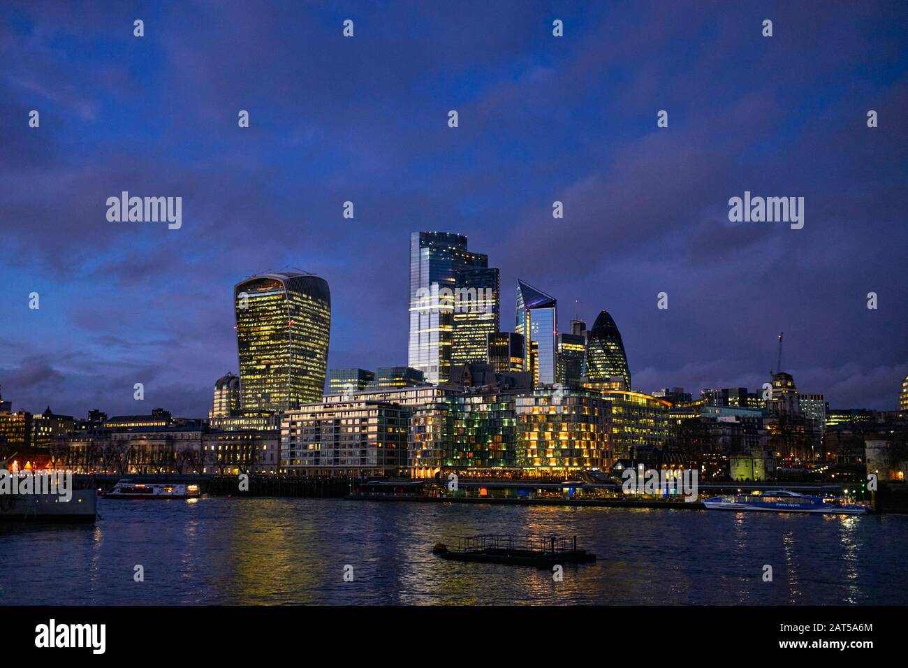 Skyline della città di Londra di notte con alti uffici illuminati contro il cielo di prima sera Foto Stock