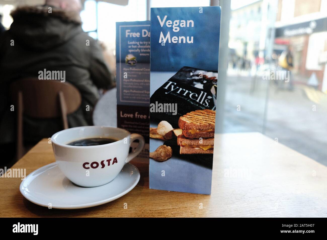 Una carta del menu vegano su un tavolo in una caffetteria Costa su un High St. La catena offre una gamma di prodotti sostitutivi del latte, spuntini e zuppe per soddisfare i Vegani Foto Stock