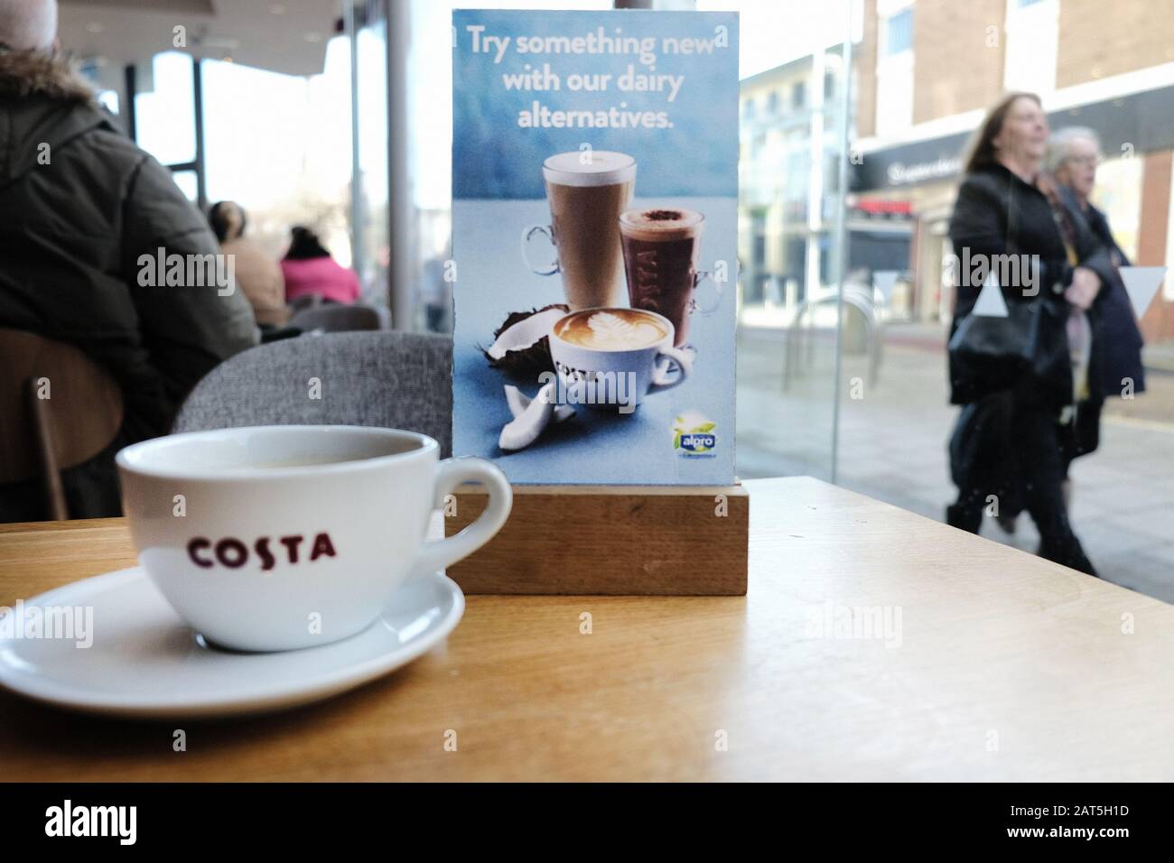 Una carta del menu alternativa del latte su un tavolo in una scelta di caffè Costa. La catena offre una gamma di prodotti sostitutivi del latte, spuntini e zuppe per soddisfare i Vegani Foto Stock