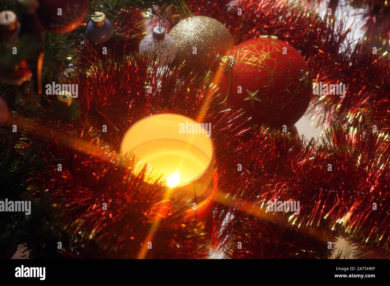 Decorazioni natalizie e candela illuminata. Atmosfere natalizie. Foto Stock