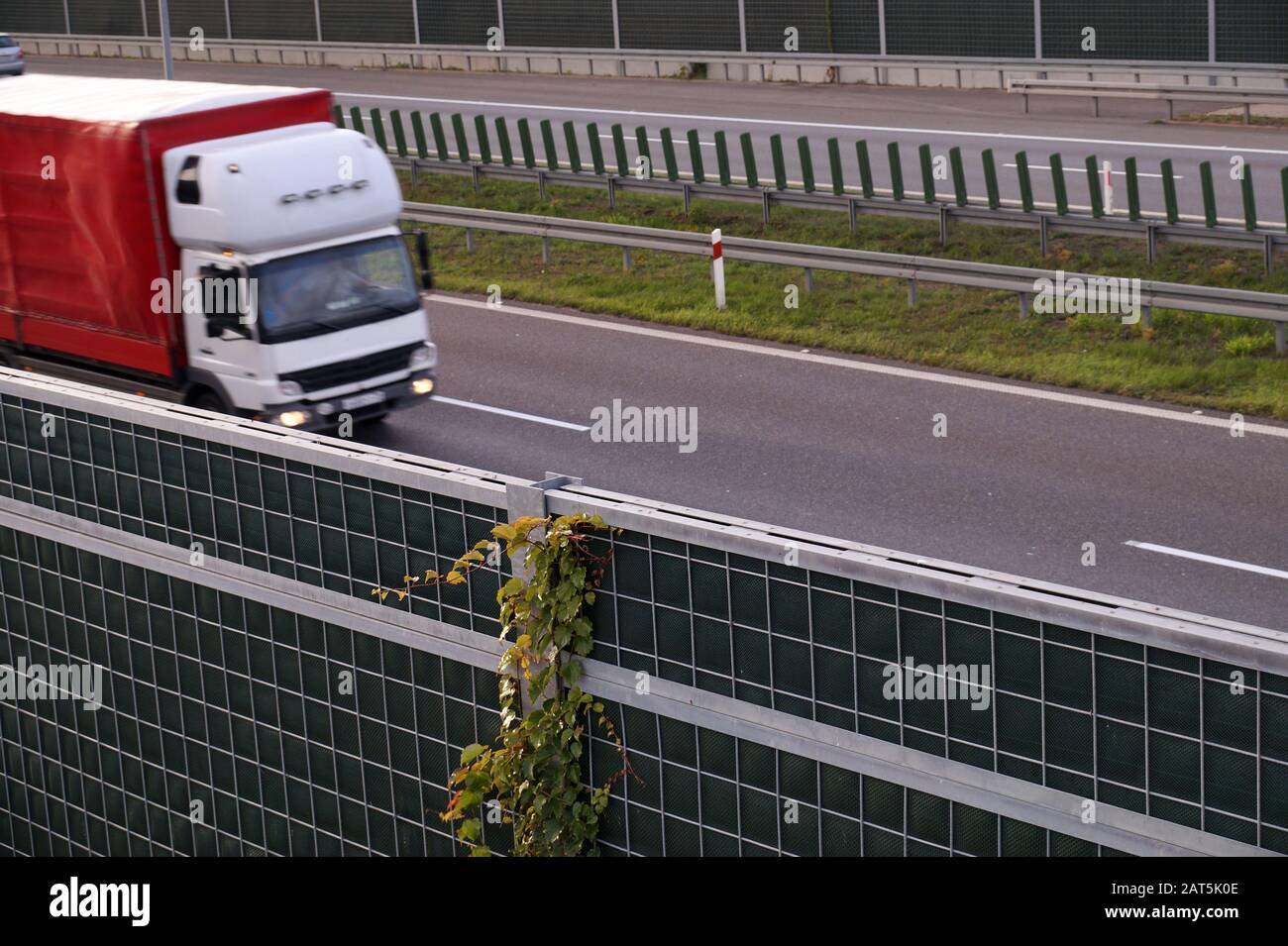 Autunno. Barriere acustiche sull'autostrada coperte da impianti di risalita. Foto Stock