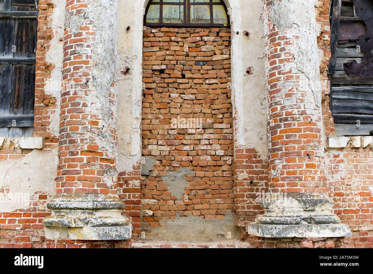 muro di un edificio abbandonato, l'ingresso al quale è calciato, e le finestre sono saliti Foto Stock