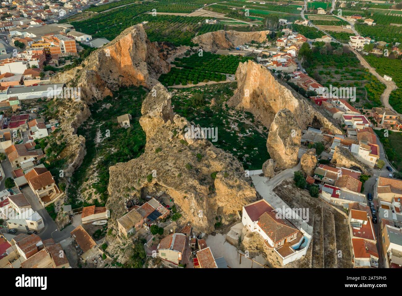 Veduta aerea del guscio di una ex cava di pietra di montagna con interessanti formazioni rocciose e scanalature arancioni all'interno di Monteagudo Spagna vicino Murcia Foto Stock