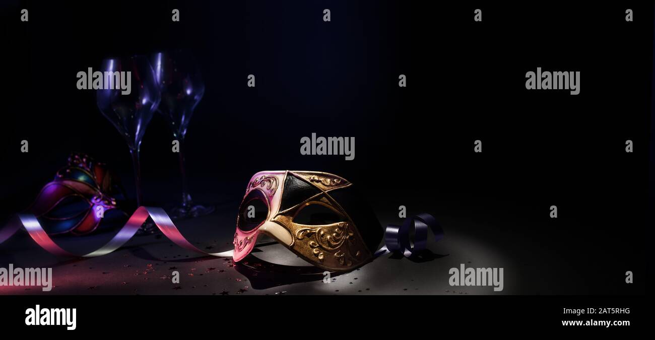 Maschera veneta carnevale con bicchieri e nastri in ambiente scuro Foto Stock