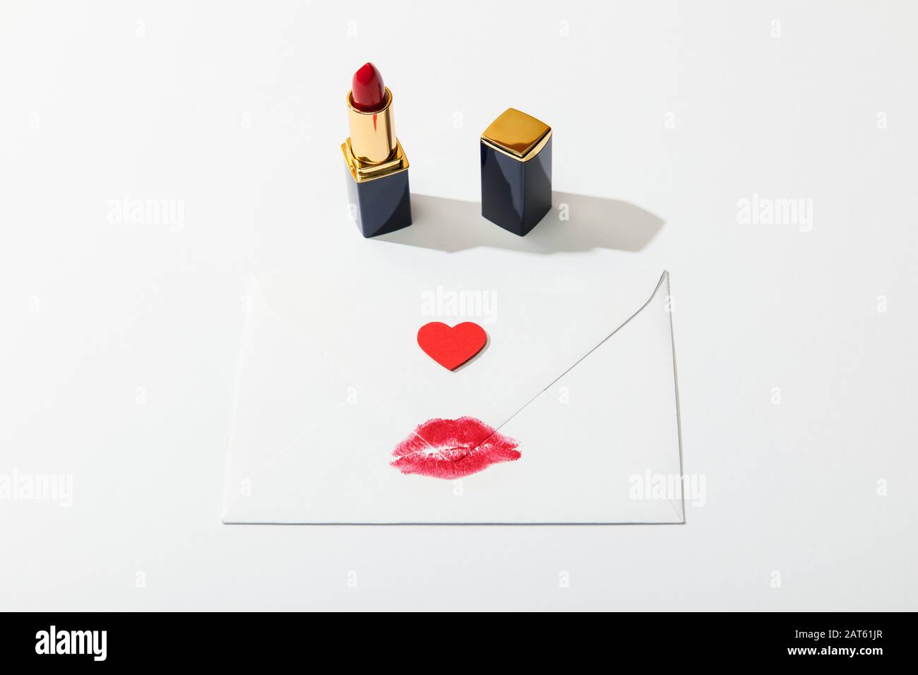 busta con stampa a labbro e cuore vicino al rossetto rosso su sfondo bianco Foto Stock