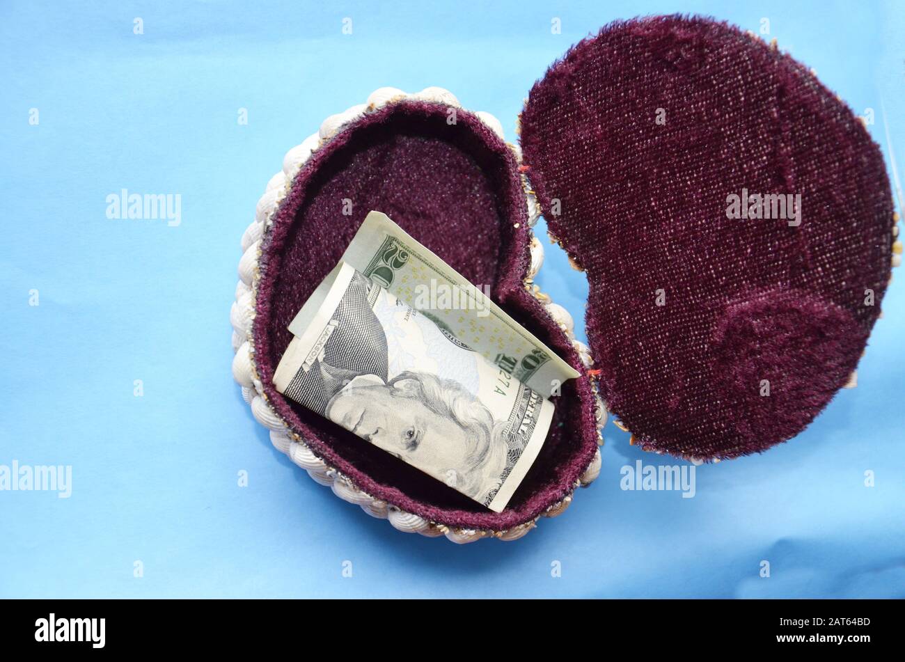 Ci sono dollari in una scatola splendidamente decorata. Su sfondo blu, vista dall'alto Foto Stock