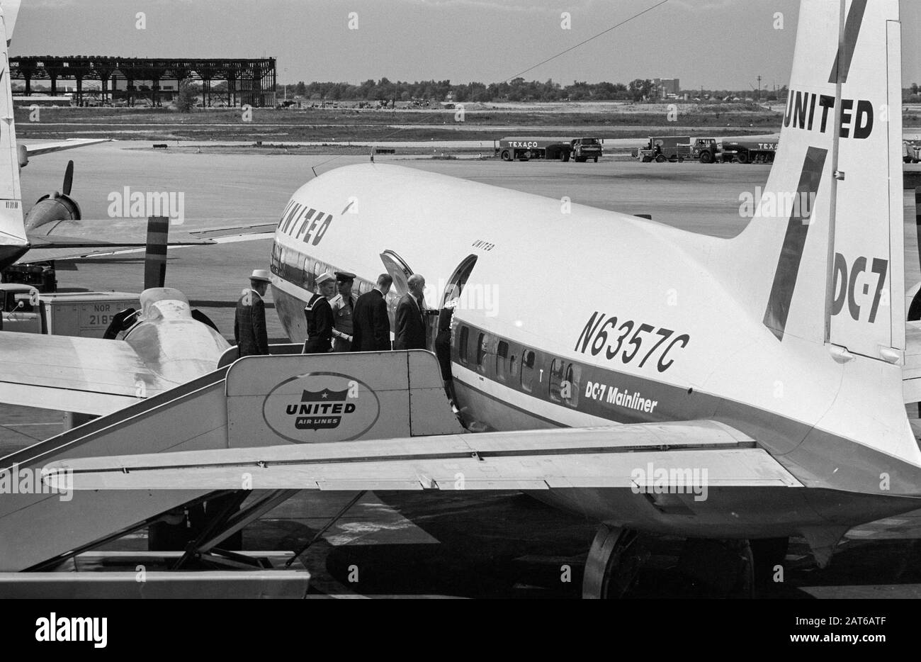 Una fotografia vintage in bianco e nero scattata nel luglio 1961 all'Aeroporto o'Hare di Chicago negli Stati Uniti. I passeggeri stanno imbarcando su una United Airlines Douglas DC-7, N6357C, utilizzando i gradini mobili. Foto Stock