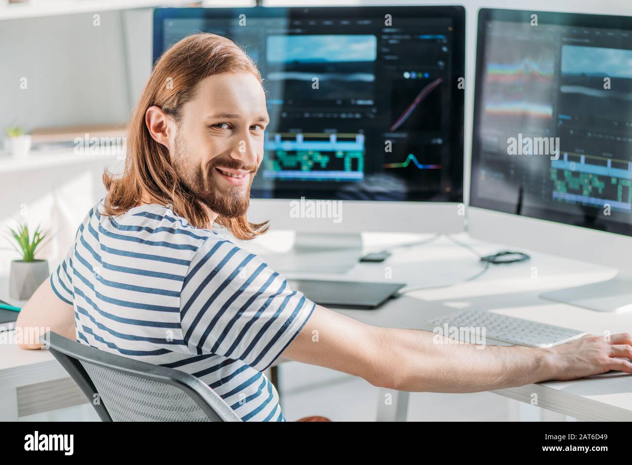 allegro editor d'arte barbuto che lavora in studio Foto Stock