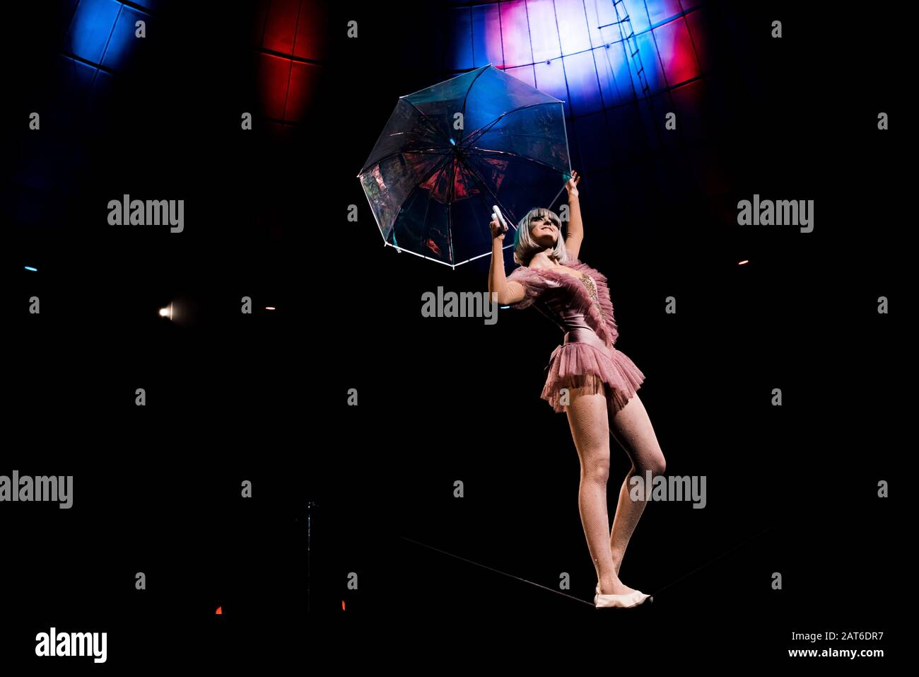 vista ad angolo basso di acrobata aerea in costume che tiene l'ombrello e  sta sulla corda Foto stock - Alamy