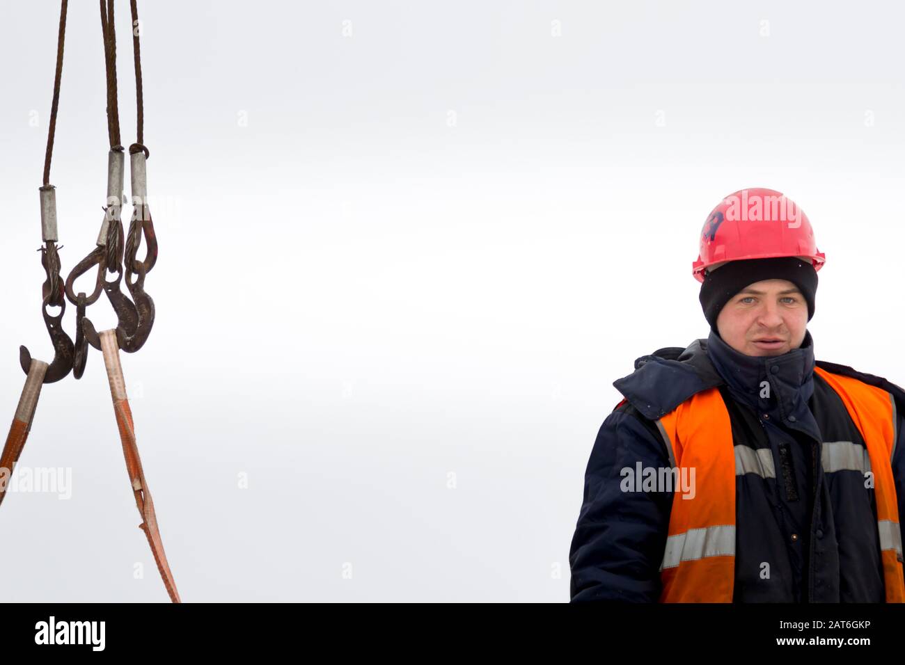 Ritratto di un operaio in un casco arancione al luogo di lavoro Foto Stock