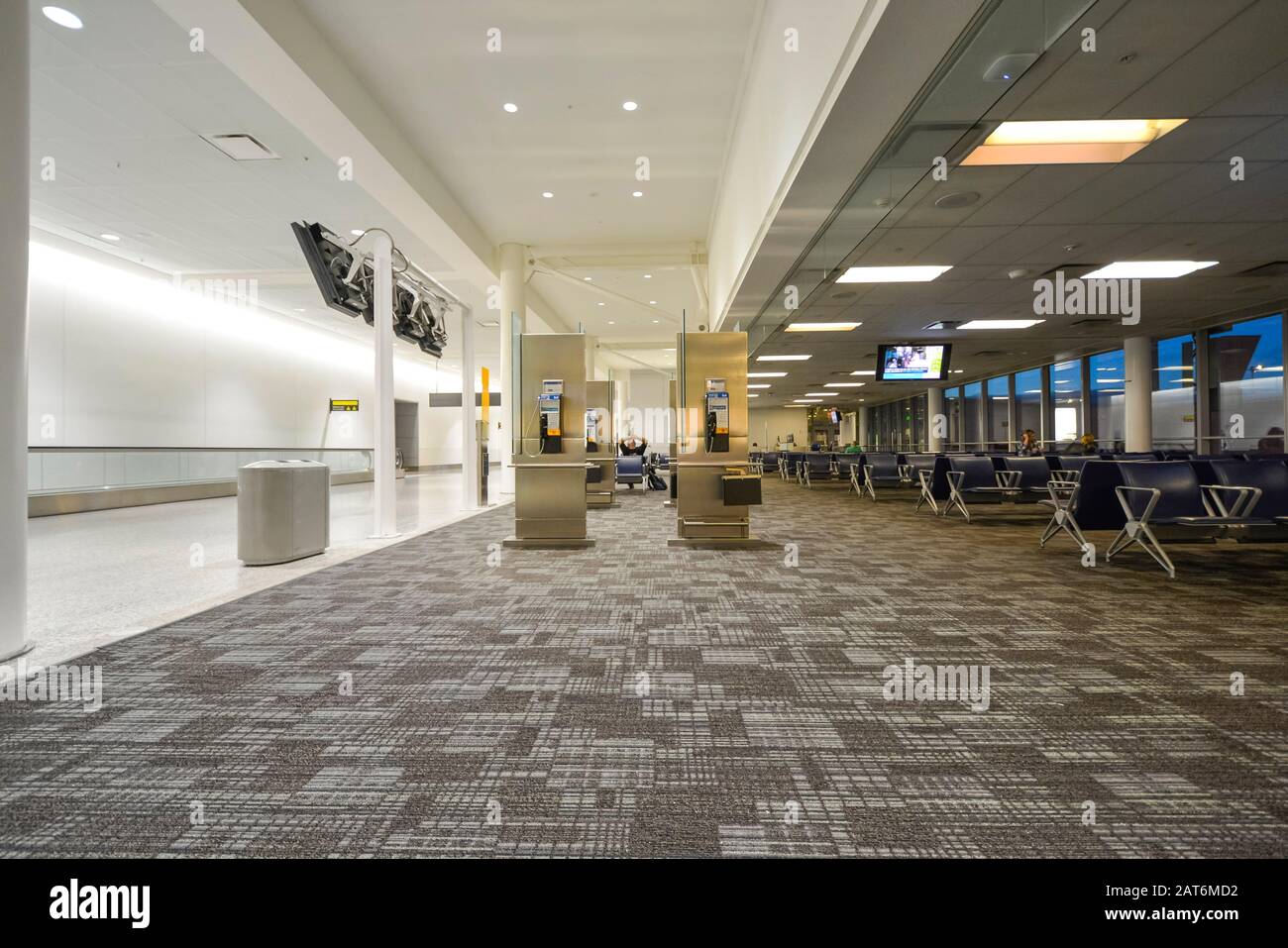 Terminal dell'aeroporto quasi vuoto la mattina presto, con pochissimi passeggeri in attesa. Foto Stock