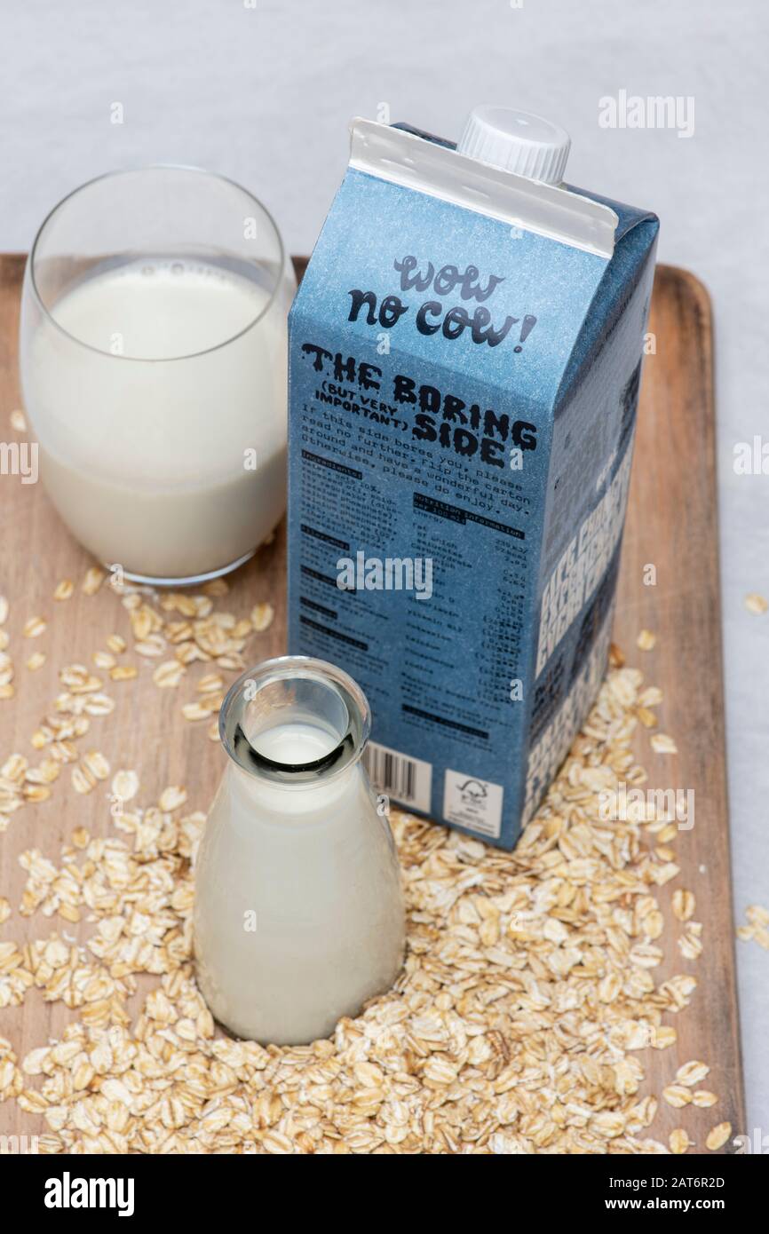 Alternative di latte a base vegetale vegano. Latte di OAT e avena su una tavola di legno Foto Stock