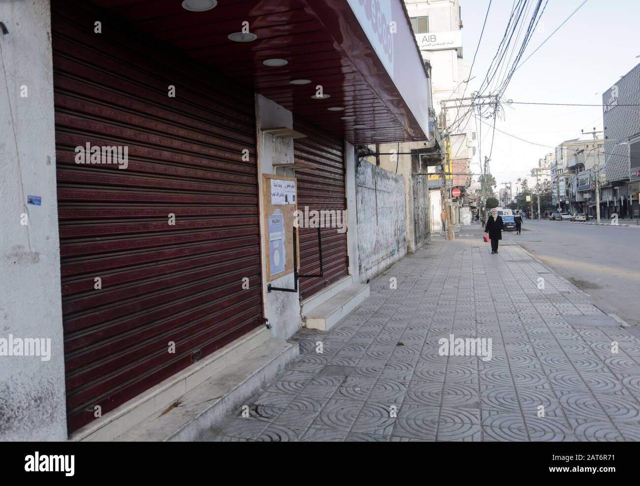 Città Di Gaza, Palestina. 30th Gen 2020. Una donna palestinese passa davanti a negozi chiusi durante lo sciopero generale per protestare contro il piano di pace degli Stati Uniti a Gaza City. Credit: Sopa Images Limited/Alamy Live News Foto Stock