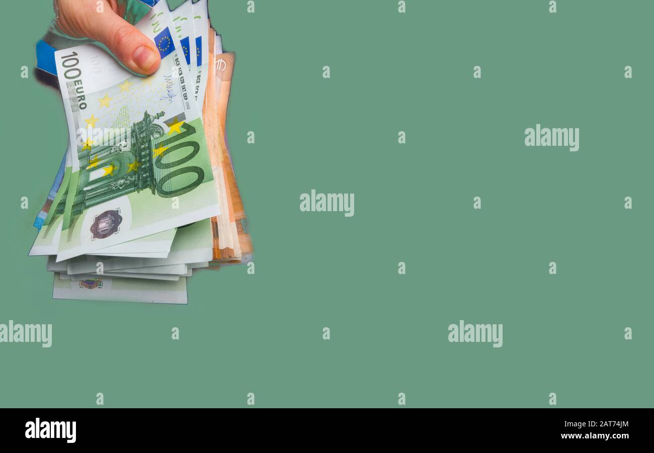 mano appare euro valuta all'interno buco da carta strappata, il concetto di dono in contanti, sorpresa, vittoria, tasse di trattamento, tangenti, chirurgia illegale. Foto Stock