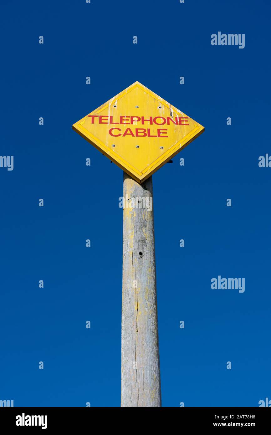 Segnale di informazione giallo avvertenza del cavo telefonico su Aldeburgh Beach Foto Stock