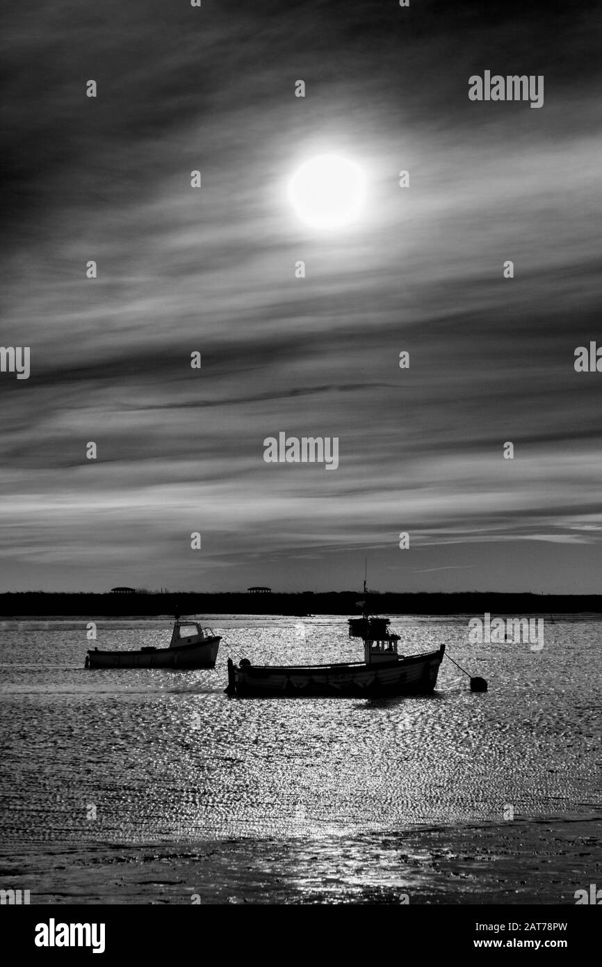 Barche in silhouette a Orford, Suffolk, Regno Unito Foto Stock