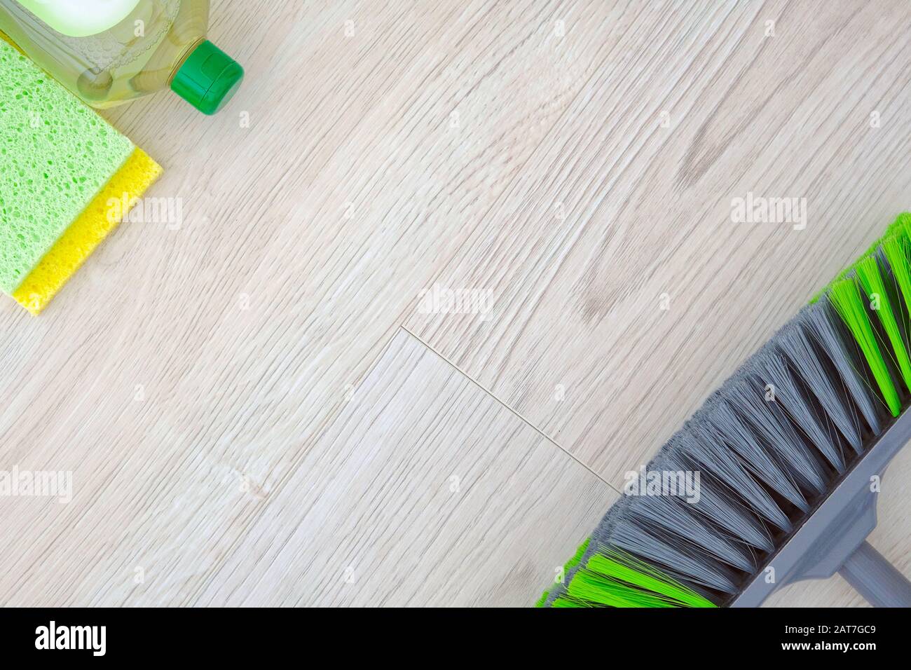 Set di prodotti per la pulizia verde su sfondo di legno. Detergente in flacone di plastica, spugne e spazzola. Сleaning accessori. Vista dall'alto. Spazio di copia. Foto Stock