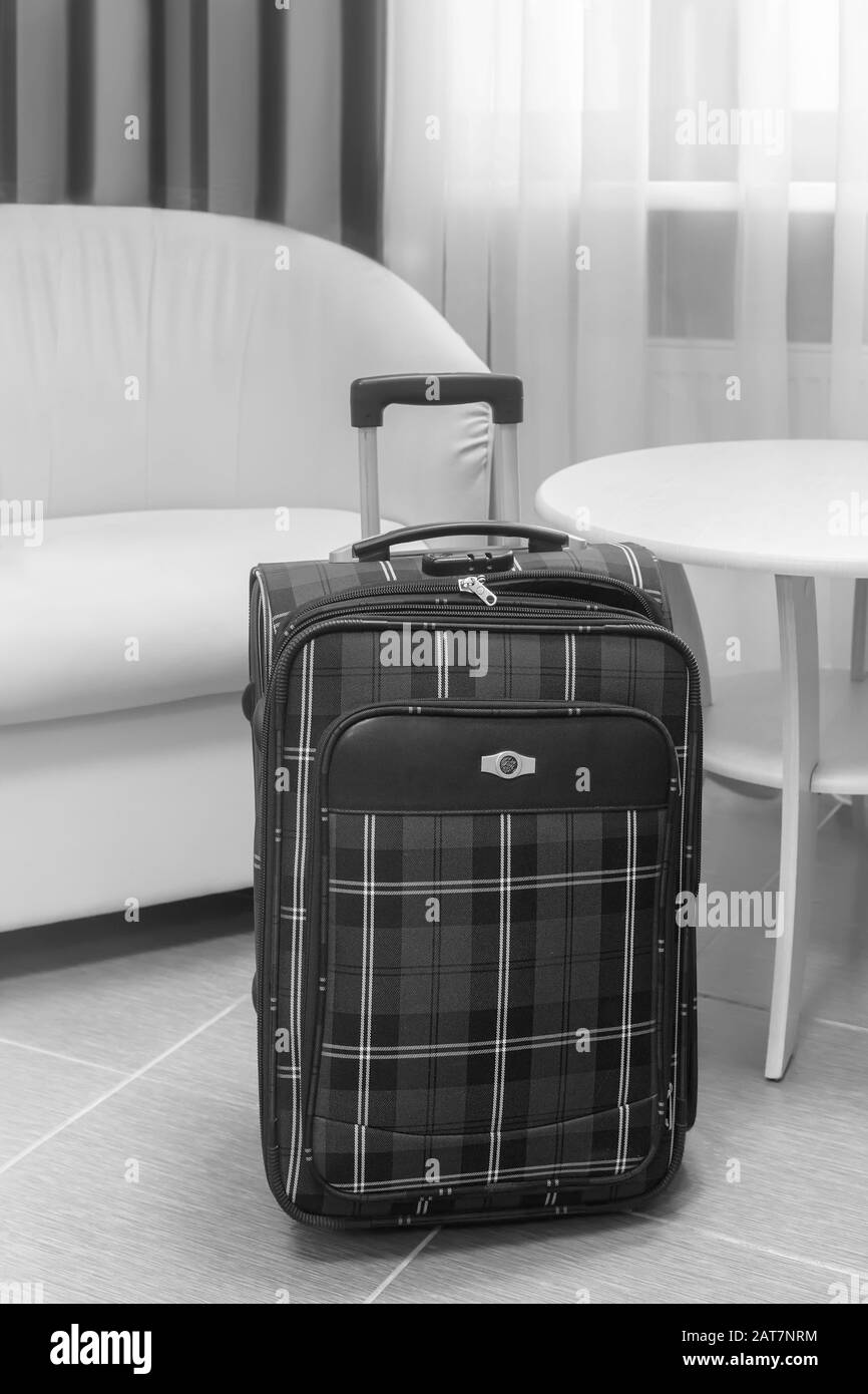 Valigia da viaggio in una camera accogliente Foto Stock