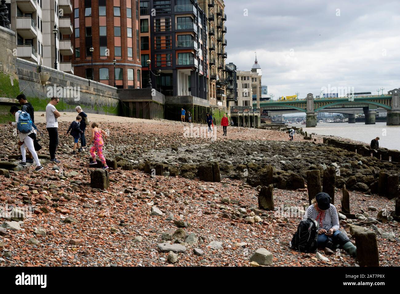 Mudlarks sul fiume Tamigi si affaccia a bassa marea, vicino al Millennium Bridge, Londra. Foto Stock