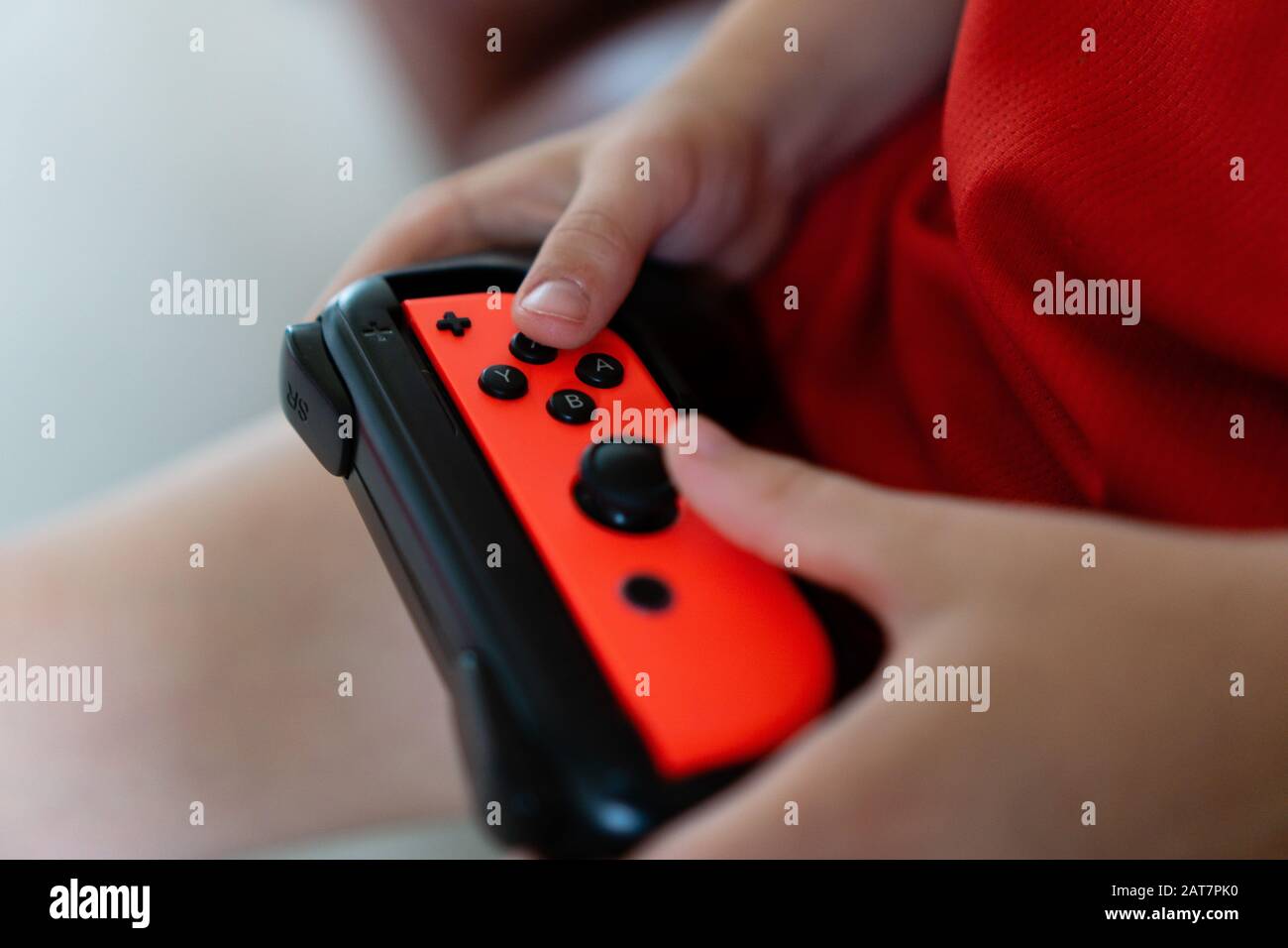 Bambino che gioca con un controller Nintendo Switch Foto Stock