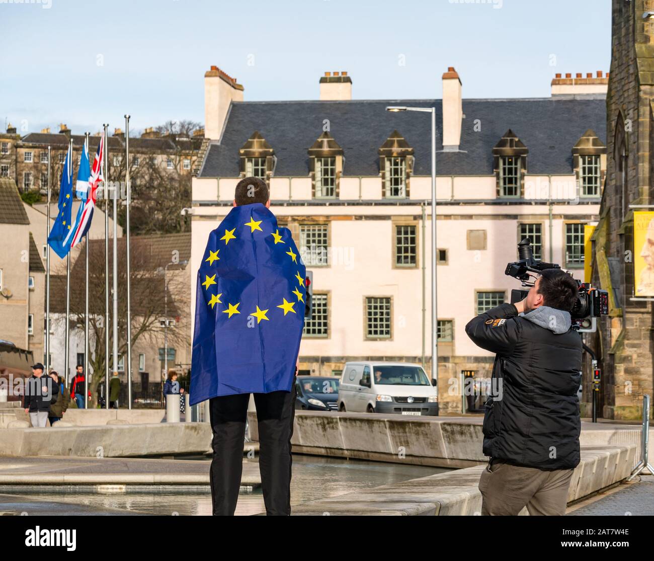 Holyrood, Edimburgo, Scozia, Regno Unito. 31st Gen 2020. Un sostenitore anti-Brexit al parlamento scozzese che si è basato sulla Brexit per protestare contro la Brexit. Fergus, uno scolari scozzese indossa una bandiera dell'UE mentre viene girato da un cameraman della Channel 4 News Foto Stock