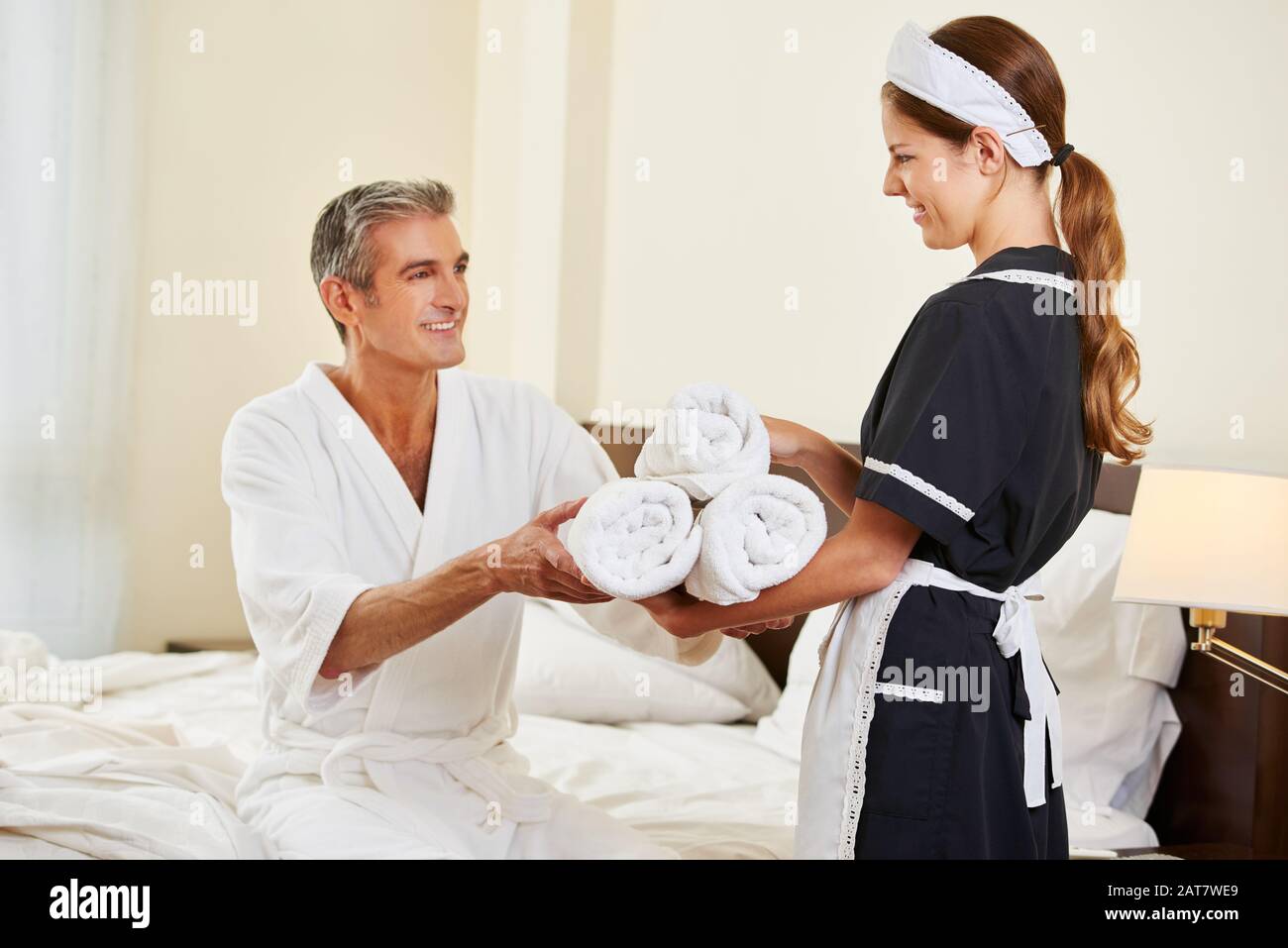Il servizio in camera dell'hotel porta asciugamani freschi ad un ospite Foto Stock