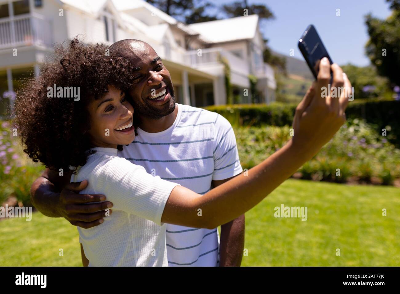 Felice giovane coppia che prende selfie nel giardino Foto Stock