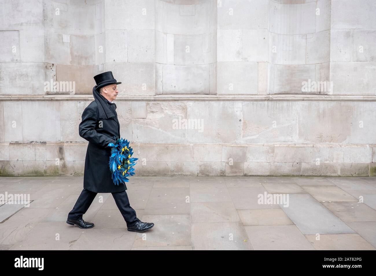Londra, Regno Unito. 31 Gennaio 2020. Un uomo vestito come un'impresa cammina lentamente lungo Whitehall tenendo una barriera funebre dell'Unione europea con 11 stelle gialle. Foto Stock