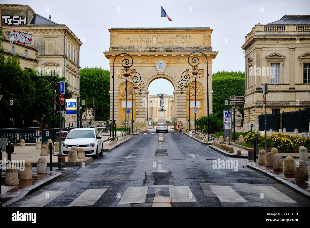 Foch strada che conduce alla Porte du Peyrou su una mattina grigio umido con auto che passa attraverso il cancello. Montpellier, Francia, 2 Maggio 2019 Foto Stock