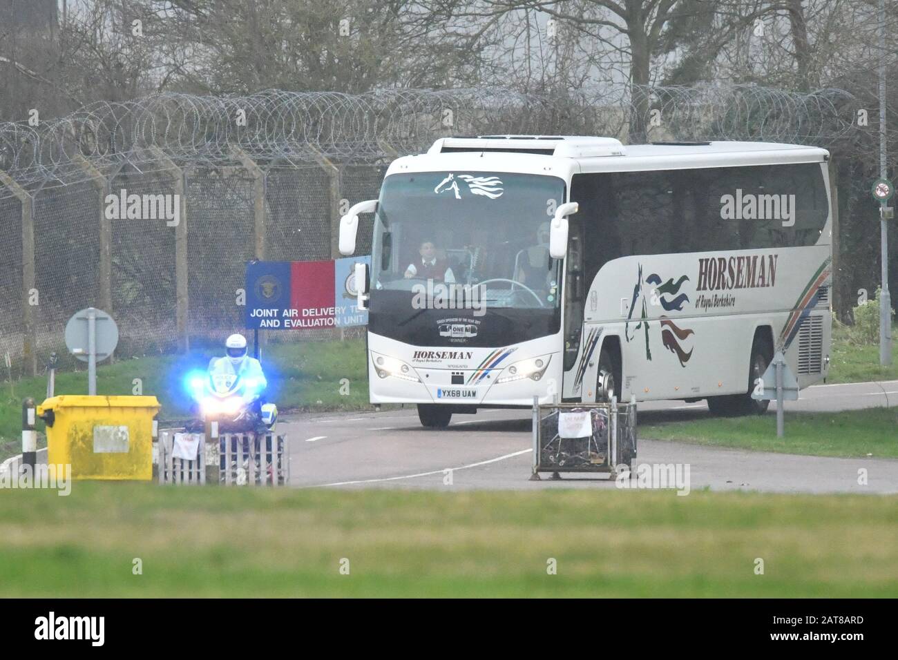 Il convoglio di autobus e ambulanza lascia Brize Norton, Oxfordshire, con una scorta della polizia, che trasporta passeggeri da un aereo che trasportava cittadini britannici dalla città colpita dal coronavirus di Wuhan in Cina. Foto Stock