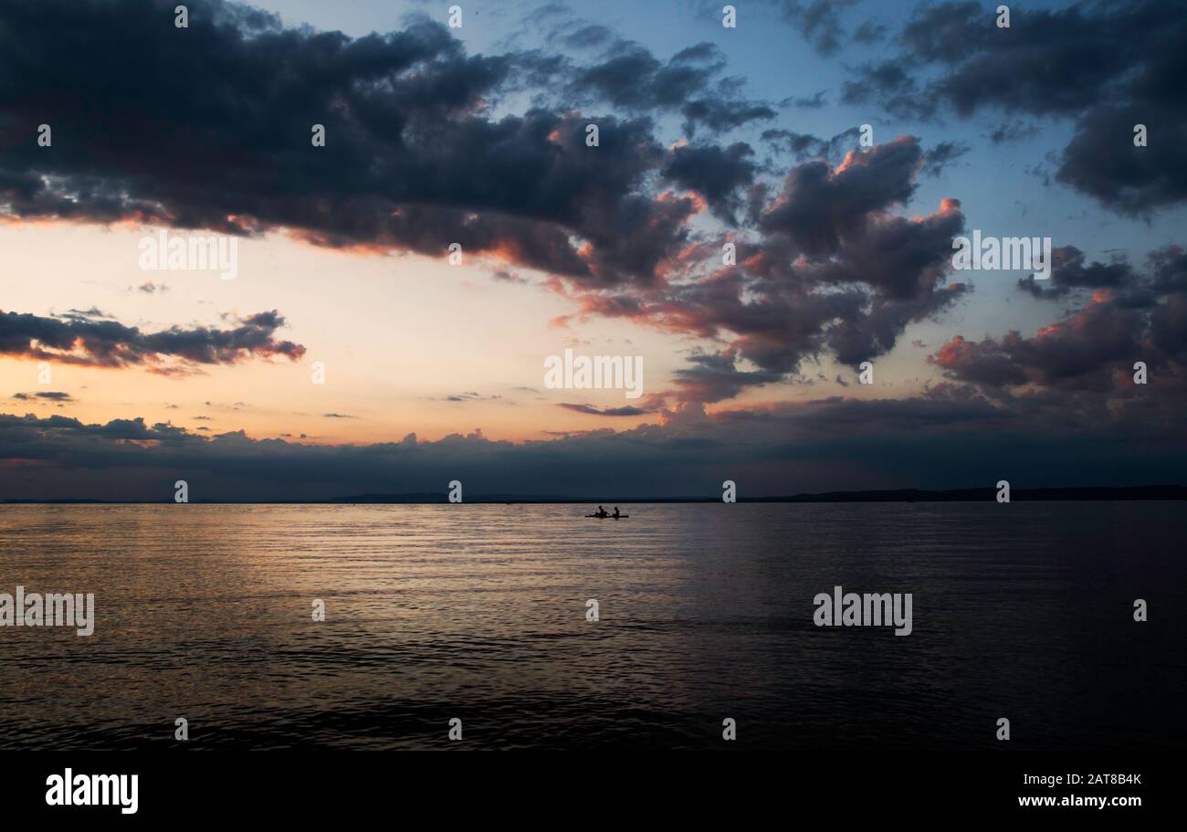 Silhouette SUP sul lago con cielo spettacolare al tramonto Foto Stock