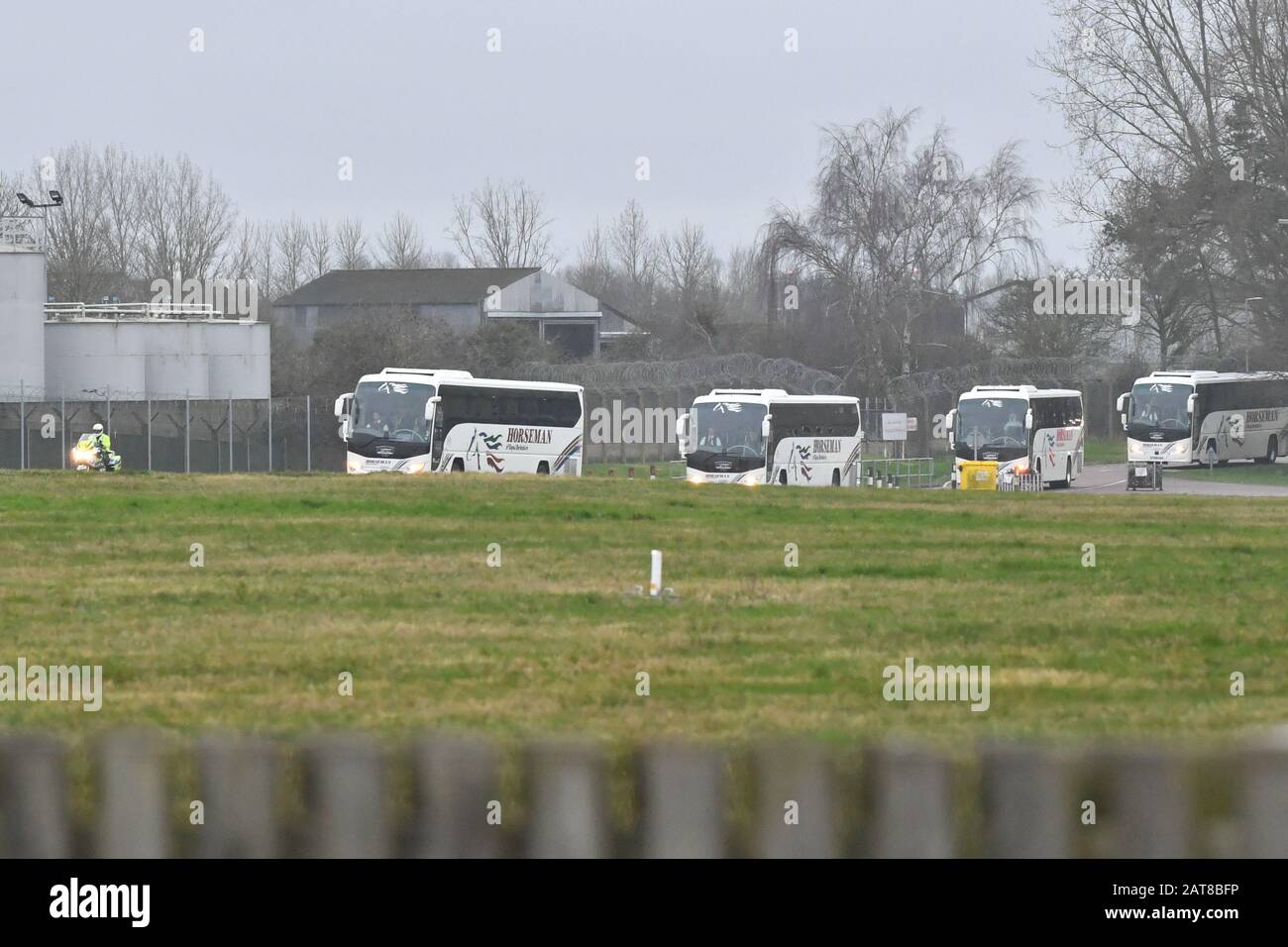 Il convoglio di autobus e ambulanza lascia Brize Norton, Oxfordshire, con una scorta della polizia, che trasporta passeggeri da un aereo che trasportava cittadini britannici dalla città colpita dal coronavirus di Wuhan in Cina. Foto Stock