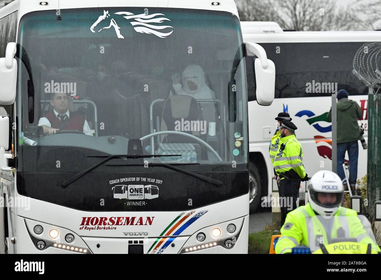 Il convoglio di autobus e ambulanza lascia Brize Norton, Oxfordshire, con una scorta della polizia, che trasporta passeggeri da un aereo che trasportava cittadini britannici dalla città colpita dal coronavirus di Wuhan in Cina. Foto Stock