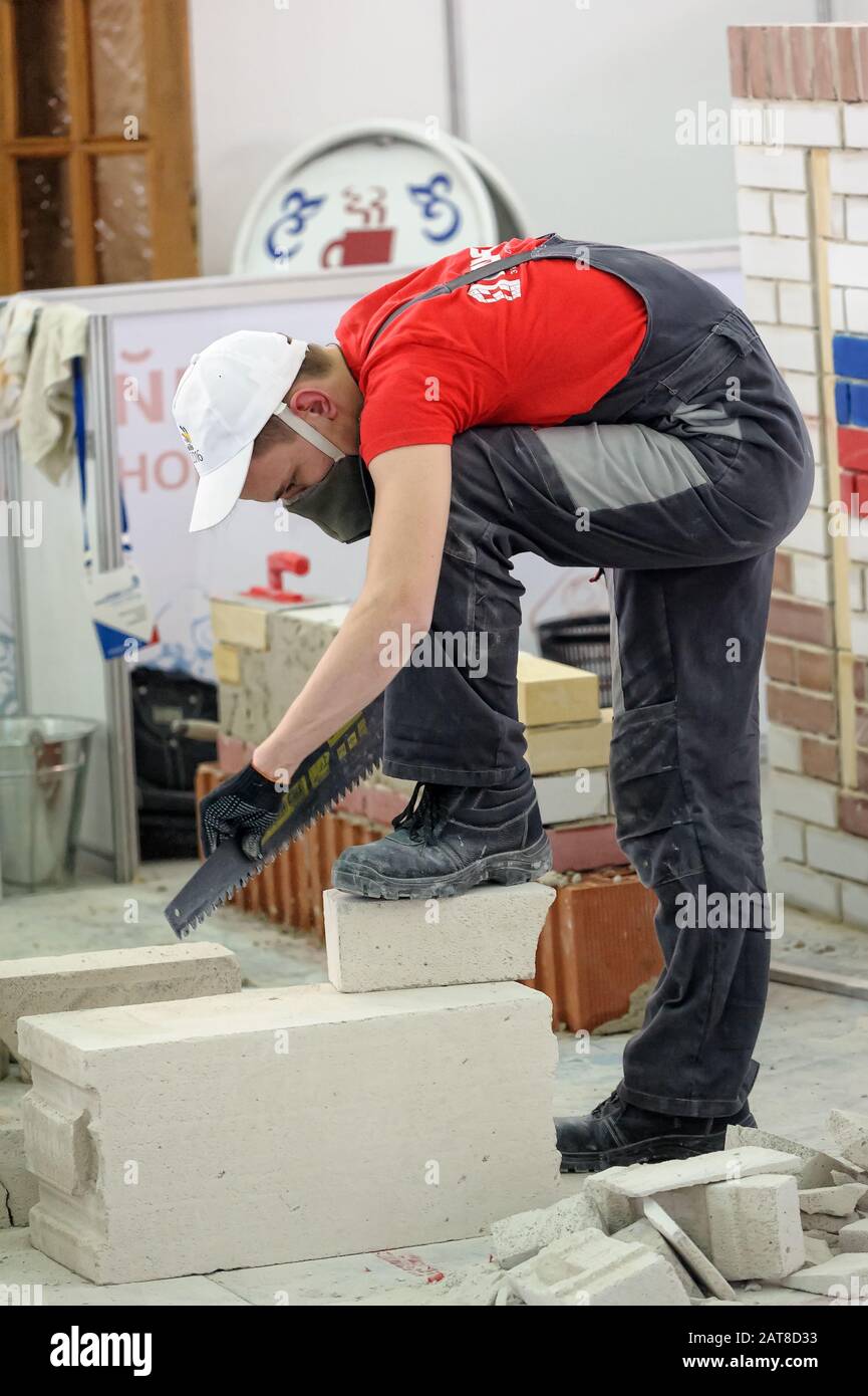 Giovane muratore esegue un compito della concorrenza Foto Stock