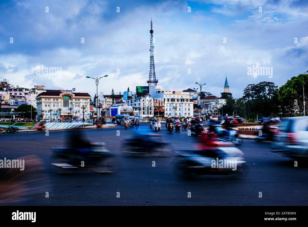 Scena urbana con il movimento sfocato del traffico di passaggio e moto su strada larga. Foto Stock